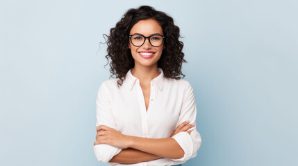 Wall Mural - Smiling woman with curly hair and glasses, wearing a white shirt, against light grey background