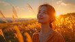 Asian woman with a subtle smile basks in the warm glow of a golden sunset amidst a field.