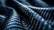 © Worrapol - Closeup of carbon fiber fabric, highlighting its texture and details. The material is a dark blue with black highlights, creating an industrial look