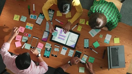 Top view of software developer writing idea about Ux ui design for mobile phone interface. Programmer brainstorm and planning wireframe prototype by looking tablet display smart software. Convocation.