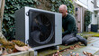 © Fokke Baarssen - Engineer worker installing an air source heat pump unit outdoors at house in the Netherlands, warmte pomp, translation air source heat pump, airco for warming and cooling, energy transition