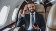 Successful and handsome businessman in suit talking on cell phone sitting on plane during business trip
