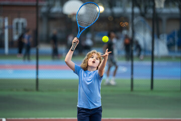 Canvas Print - Cute Kid play tennis. Little kid hit tennis ball with tennis racket. Active exercise for kids. Summer activities for children. Child learning to play tennis. Sport Kid hitting Ball on court.