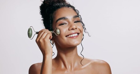 Canvas Print - Beauty, face roller and woman in studio for skincare, health and wellness massage treatment. Smile, cosmetic and portrait of model with Jade facial tool for dermatology routine by white background.