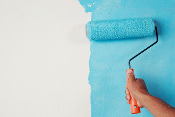 Sticker - Roller Brush Painting, Worker painting on surface wall  Painting apartment, renovating with blue color  paint. Leave empty copy space white to write descriptive text beside.