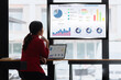 © SOMKID - Asian businesswoman working on TV screen with growth analysis data charts at the office.