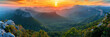 A panorama view  mountains at sunrise, with golden rays illuminating peaks and a forest, Mountain landscape at sunset, nature banner background