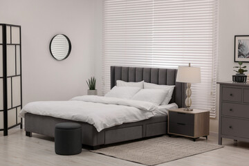 Aufkleber - Stylish bedroom interior with large bed, chest of drawers and lamp