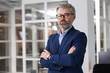 © New Africa - Portrait of handsome man with crossed arms in office, space for text. Lawyer, businessman, accountant or manager