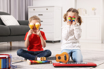 Wall Mural - Little children playing toy musical instruments at home