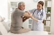 © New Africa - Arthritis symptoms. Doctor examining patient's elbow in hospital