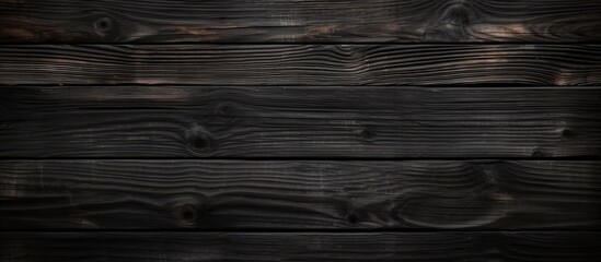 Wall Mural - A close-up view of a dark wood background with a grainy surface, showcasing the intricate texture and patterns of the wood. The surface appears to be weathered and aged, adding depth to the overall