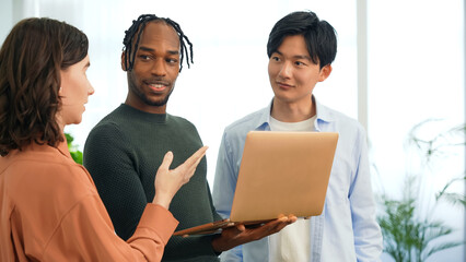 Poster - Multinational people talking while looking at laptop PC in the lobby. International business.