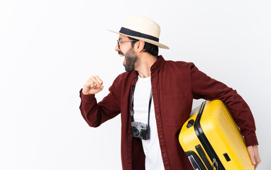 Wall Mural - Traveler man man with beard holding a suitcase over isolated white background running fast