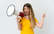 © luismolinero - Young blonde woman isolated on white background shouting through a megaphone and pointing side