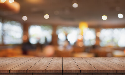 Empty wooden table top with lights bokeh on blur restaurant background.