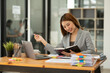 © Thitisak - Asian businesswoman holding notebook about business, spending