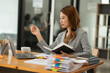 © Thitisak - Asian businesswoman holding notebook about business, spending money
