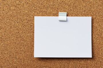 A white piece of paper is taped to a cork board