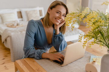 young pretty stylish woman working remote at home at table workplace, student education