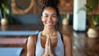 Young woman smiling at the camera in a yoga studio. Having a workout session in a fitness studio. Sport, Fitness, Health, People concept.