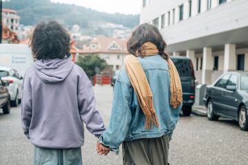 Wall Mural - happy wedding couple holding hands walking on the street