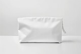 Fototapeta  - A blank white cosmetic bag is sitting on a white surface.