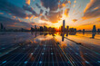 A solar panel capturing the last rays of the setting sun against a city backdrop.