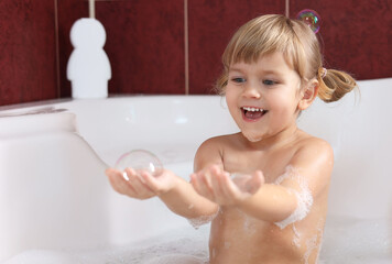 Wall Mural - Happy girl having fun in bathtub at home