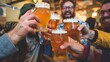 Multi-racial hipster friends drinking and toasting beer at brewery bar restaurant - Food and beverage life style concept with men and women having dinner together