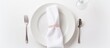 Tableware set on a plate includes fork, spoon, and glass with a napkin neatly folded on a table