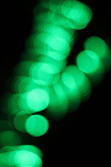 Blurry dreamy view of a blur of green lights.