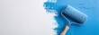 © Oleksandr - roller paints with blue paint on a white wall.