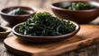 Wakame seaweed on wooden plate and dried seaweed in bowl
