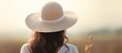 © vxnaghiyev - Serene Woman in a Stylish Hat Contemplating Nature in a Vast Countryside Landscape