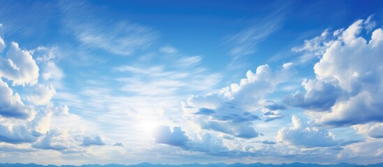 Canvas Print - Cumulus clouds parting to reveal the sun shining in an electric blue sky, casting a warm glow over the grassland landscape with a gentle breeze