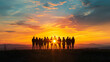 Silhouettes of diverse people stand against dramatic sunset, reflecting unity and camaraderie on scenic hilltop