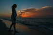 © esteban - woman looking at the sunset on the beach