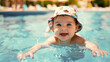 A baby is smiling and splashing in a pool. The baby is wearing a hat and is in the water
