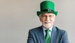 A smiling elderly man in a galsse, green hat and tie celebrates St. Patrick's Day with joy and elegance, neutral studio background