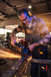 © Zamrznuti tonovi - Caucasian man working hard with his grinder while spark flying around.
