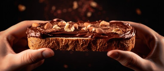 Poster - A person is holding a delicious piece of chocolate bread with nuts, a tasty dish made with ingredients including nuts, chocolate, and bread, perfect for a snack or dessert