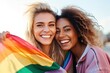 Joyful lesbian couple of two girls holding an LGBT flag in their hands, happiness and love concept