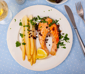 Wall Mural - Tasty baked salmon steak with asparagus garnish, lemon and fresh parsley