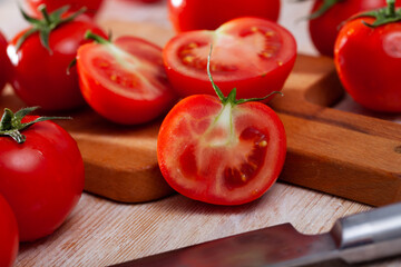 Wall Mural - Image of cut fresh tomatoes on wooden table in home kitchen