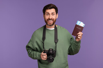 Canvas Print - Smiling man with passport, camera and tickets on purple background