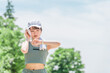 公園でトレーニング・ジョギングのインターバル中にスマートウォッチを確認する若いアジア人女性
