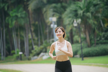 Poster - asian woman jogger running in green nature public park.