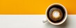 Top view of black coffee in a white cup on a half yellow, half white background.