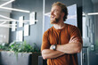 © Jacob Lund - Caucasian man smiling as he stands outside a meeting room in a business office